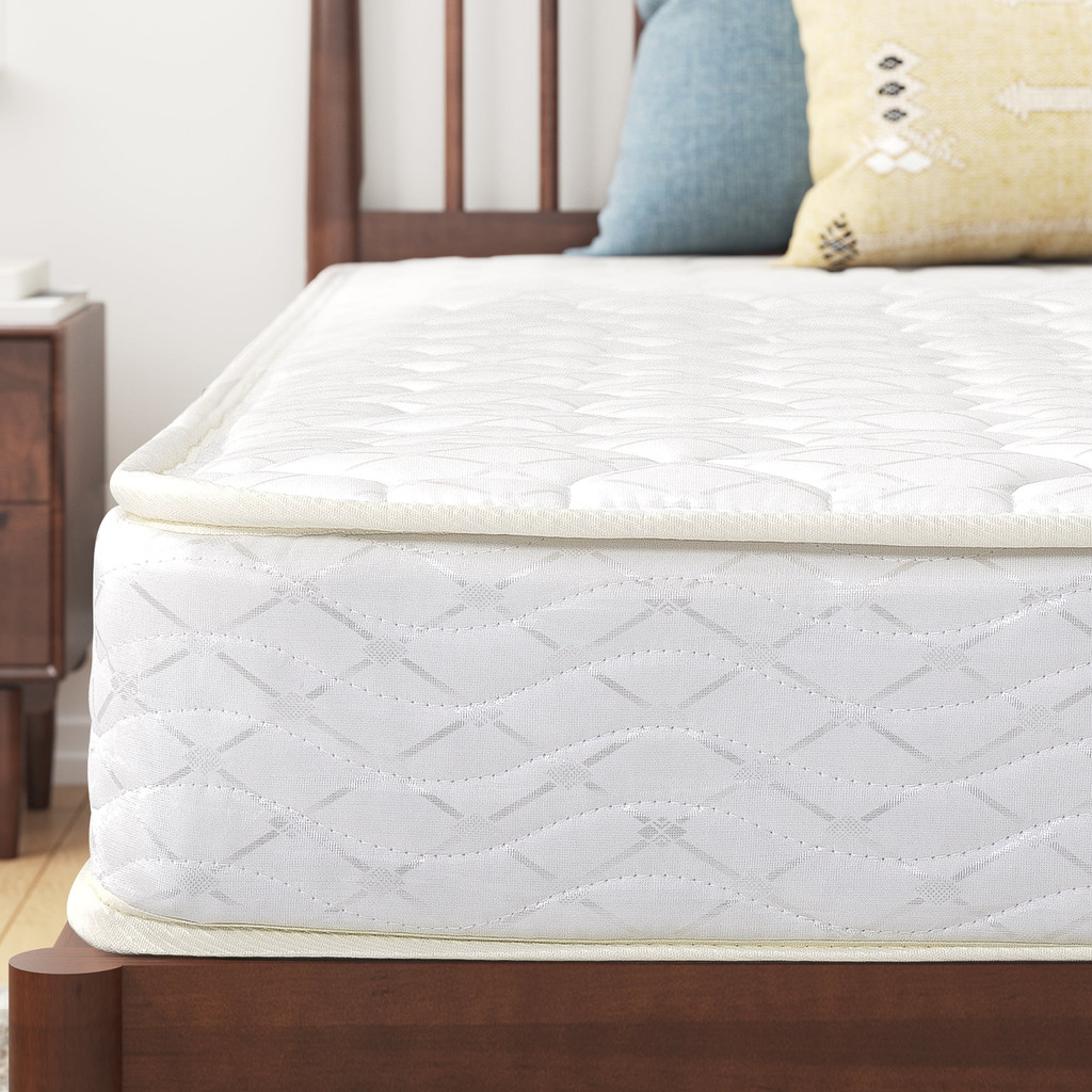 Close-up of mattress side and edge with pillow and headboard visible